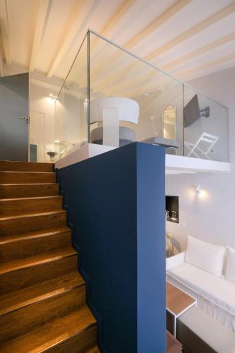a staircase leading up to a living room with a bed at MouraSuites Hotel in Évora