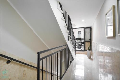 a staircase in a house with white walls and a black railing at Mate ALMA - By HOMY in Jerusalem
