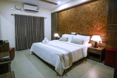 sypialnia z dużym białym łóżkiem w pokoju w obiekcie Hotel Shams Inn w mieście Koczin
