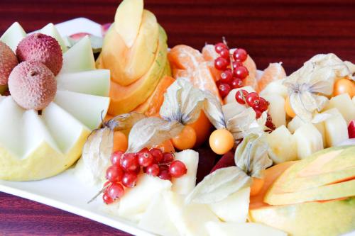 a plate of fruit and vegetables on a table at Stadthotel Stern in Wismar