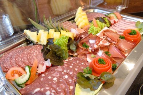 a tray of food with different types of food at Stadthotel Stern in Wismar
