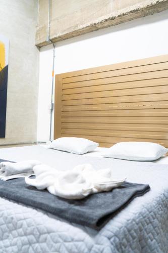 a bed with white sheets and pillows on it at M1145 Aparta Loft in Pereira