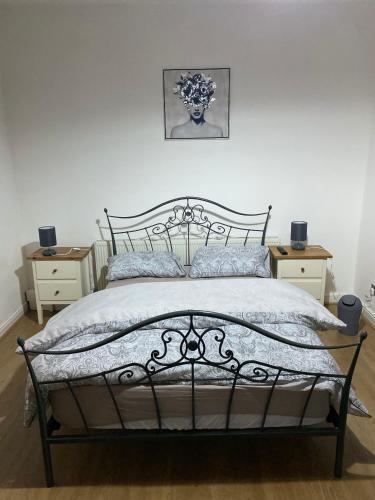 1 dormitorio con 1 cama negra y 2 mesitas de noche en Lovely 2 Bedroom Apartment with free parking en Mánchester