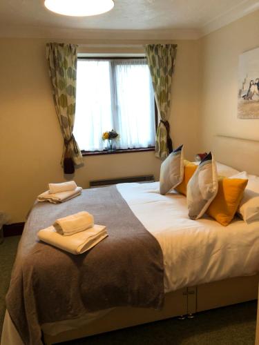 a bedroom with a large bed with towels on it at Quayside Close Holiday Apartments in Poole