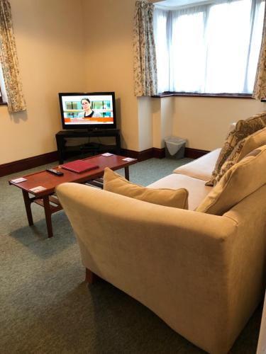 a living room with a couch and a tv at Quayside Close Holiday Apartments in Poole