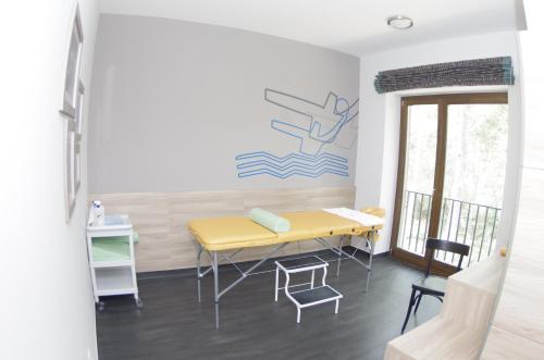 a room with a yellow table and chairs at Hotel Therapia in Pécs