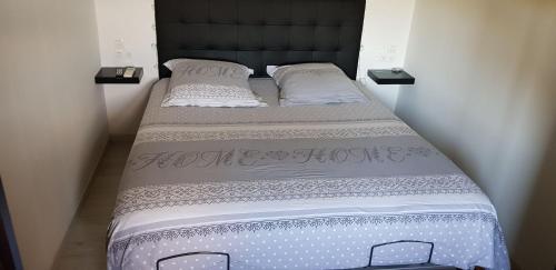 a bed in a room with two pillows on it at Le Chalet de la Pierreraie Côte d'Azur Piscine Terrasse et Vue Mer in Drap