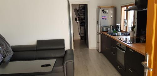 a living room with a couch and a kitchen at Le Chalet de la Pierreraie Côte d'Azur Piscine Terrasse et Vue Mer in Drap