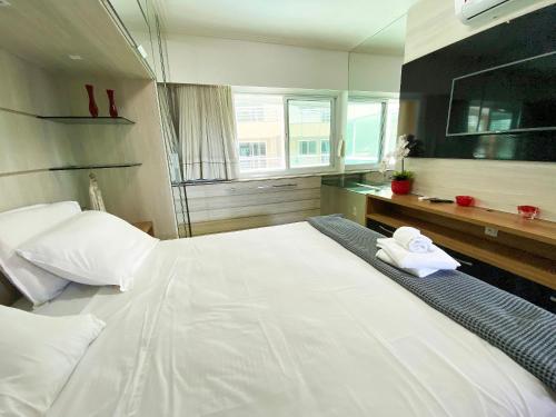 ein großes weißes Bett in einem Zimmer mit Fenster in der Unterkunft Apartamento Completo no Beach Place Cumbuco - Apto Luxo in Cumbuco