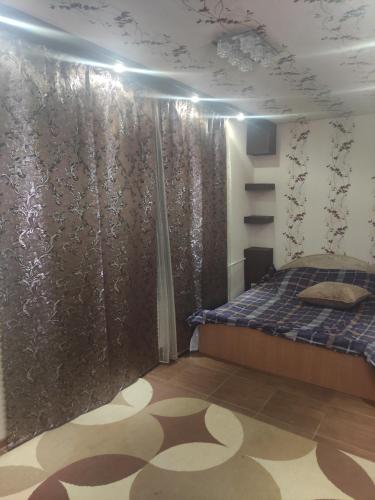 - une chambre avec un lit et un mur en verre dans l'établissement EAA, à Tiraspol