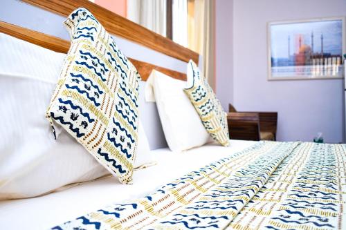 a bed with white sheets and pillows in a bedroom at VILLA DE L'INTEGRATION in Ouagadougou