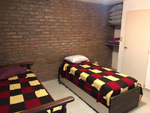 a bedroom with two beds and a brick wall at Departamento Ideal II! in Villa María