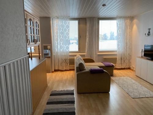 a living room with a couch and a chair and a television at Apartment Isokatu in Kokkola