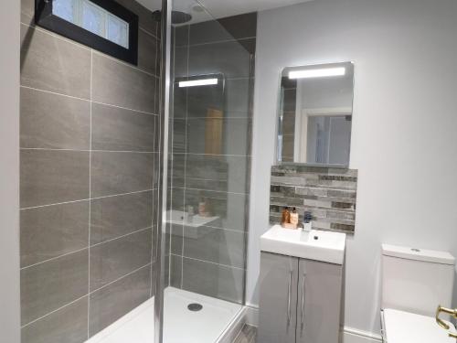 un bagno con doccia, WC e lavandino di Corner House Cottage a Ilkeston