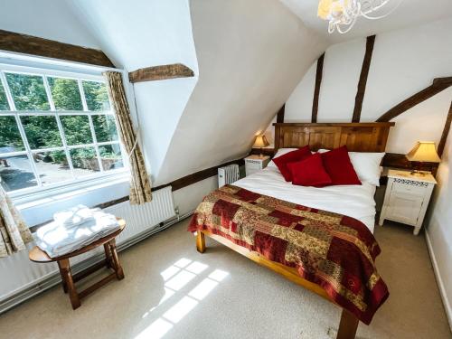 a bedroom with a bed and a window at The Peacock Inn in Chelsworth