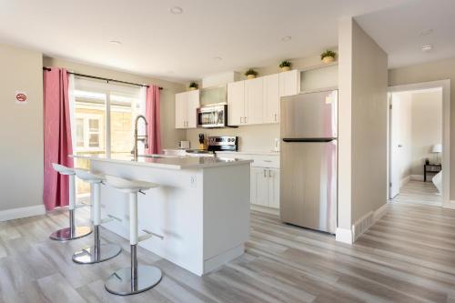 a kitchen with white cabinets and a stainless steel refrigerator at ENTIRE 2 BEDROOM APARTMENT DOWNTOWN - u2 in Kitchener