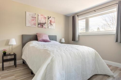 a bedroom with a bed and a window at ENTIRE 2 BEDROOM APARTMENT DOWNTOWN - u2 in Kitchener