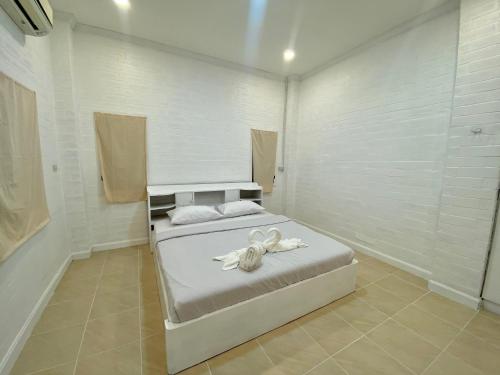 Un dormitorio con una cama con toallas blancas. en Whitehouse cafe&Guesthouse en Ban Sa La
