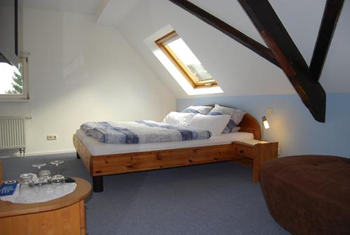 ein Schlafzimmer mit einem Bett und einem Dachfenster in der Unterkunft Kronenhof - Wein und Ferien in Gau-Algesheim