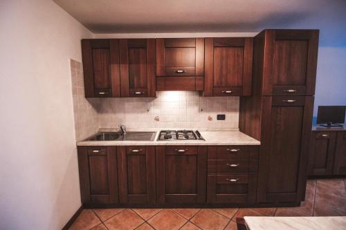 una cocina con armarios de madera y fregadero en Residence Aquila - Bilo Testa di Comagna, en Brusson