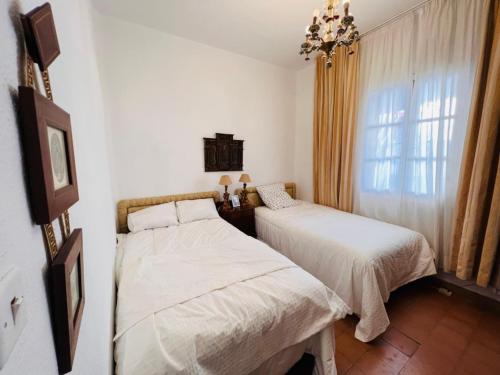 a bedroom with two beds and a window at APCH5 Marga in Chinchón