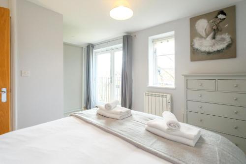 a bedroom with a bed with two towels on it at The Loft - Aldeburgh Coastal Cottages in Leiston