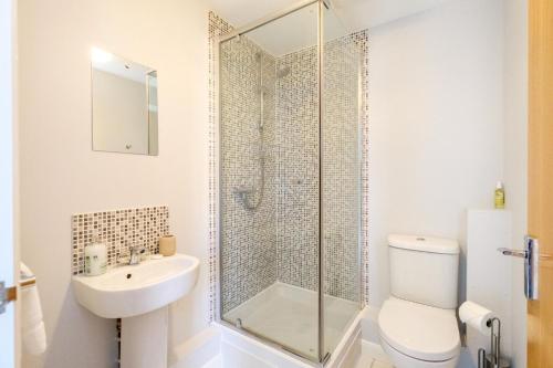 a bathroom with a shower and a toilet and a sink at The Loft - Aldeburgh Coastal Cottages in Leiston