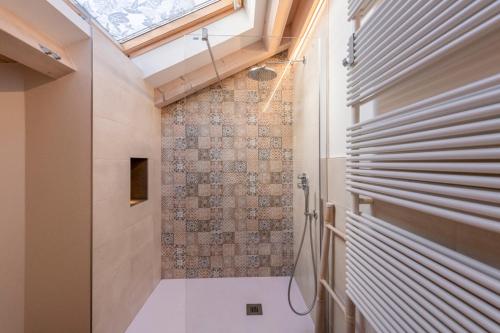 a bathroom with a shower and a skylight at Sweet Dolomites Sauna & Jacuzzi in Agordo