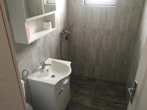 W łazience znajduje się biała umywalka i prysznic. w obiekcie Motel Capljina Center w mieście Čapljina