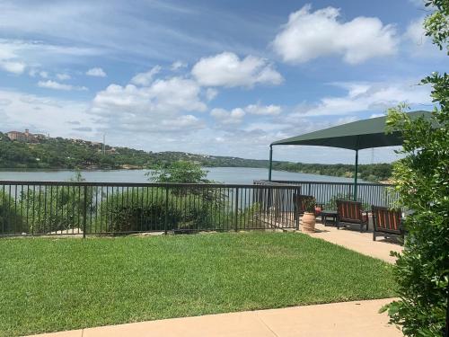 un patio con 2 bancos y una sombrilla verde en Hidden Falls Inn, en Marble Falls