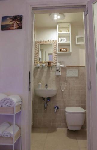 a bathroom with a sink and a toilet and a mirror at Loft Le Gemelle in Bari