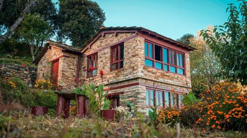 an old stone house in the middle of a field at Itmenaan Estate in the Himalayas in Almora