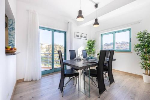 a dining room with a black table and chairs at Casa das Cores in Albufeira