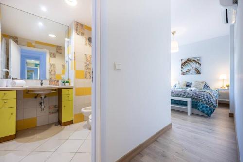 a bathroom with a sink and a bedroom with a bed at Casa das Cores in Albufeira