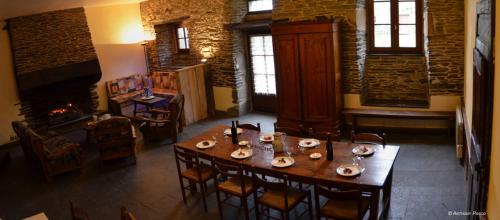 une salle à manger avec une table et une cheminée dans l'établissement MANOIR DU LISCUIS, à Laniscat