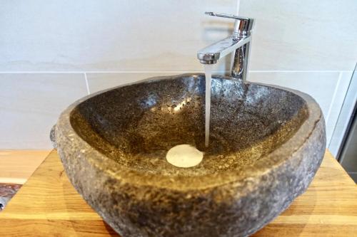 a stone sink with a faucet on a wooden table at Ferienhaus Bergglück in Nonnweiler