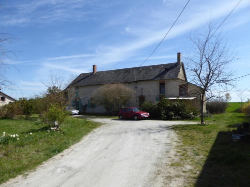 a house with a red car parked next to a dirt road at joli gite au calme proche d'Issoudun (17 km) in Giroux