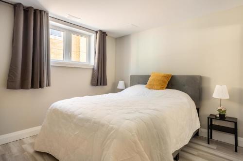 - une chambre avec un lit doté d'un oreiller jaune dans l'établissement ENTIRE 2 BEDROOM APARTMENT DOWNTOWN - u1, à Kitchener