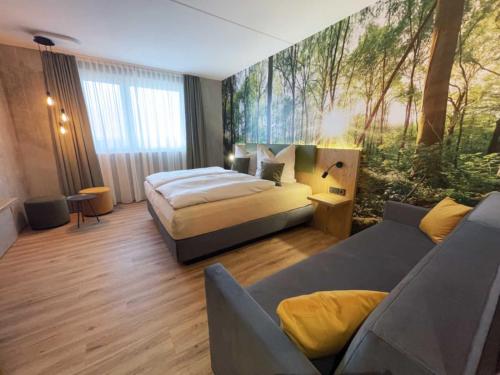 LichtenauにあるHotel am Sonnenlandparkのベッドとソファ付きのホテルルーム