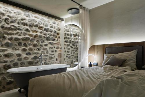 1 dormitorio con cama, bañera y lavamanos en Truma Swing Luxury, en Merano