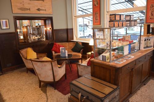 a room with a store with chairs and a table at Storyhotel Bergischer Hof Königswinter in Königswinter