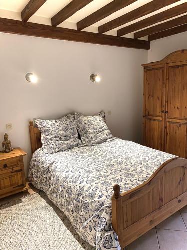 une chambre avec un lit et une armoire en bois dans l'établissement Maison traditionnelle Normande avec piscine, à Hotot-en-Auge