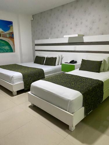 two beds in a hotel room with at Hotel Genova Prado in Barranquilla