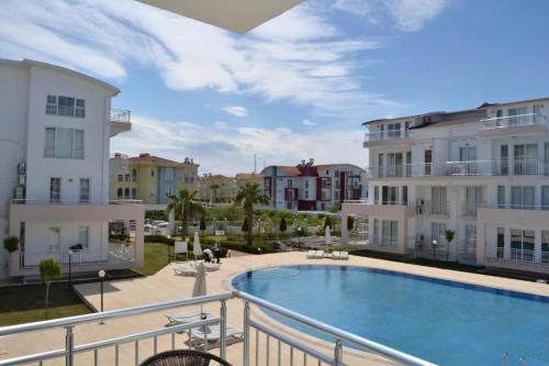 a balcony with a swimming pool and buildings at Antalya belek 1 Nirvana club first floor two bedrooms pool view with water slide close to center in Belek