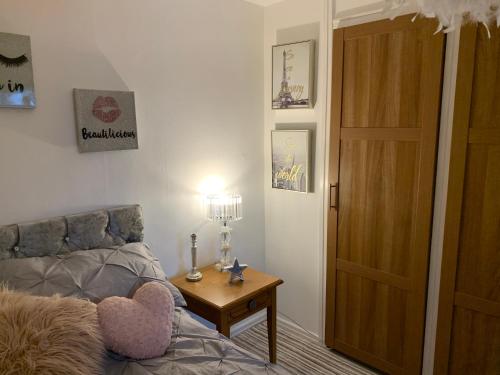 a bedroom with a bed and a table and a door at Sunny rhyl apartment in Rhyl