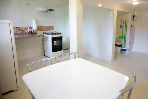 a kitchen with a white table and a white stove at Flats Martinez in Conservatória