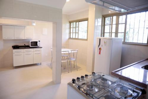 a kitchen with a white refrigerator and a table at Flats Martinez in Conservatória