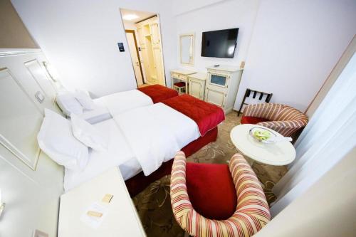 a bedroom with a bed and a table and a chair at Pleiada Boutique Hotel & Spa in Iaşi