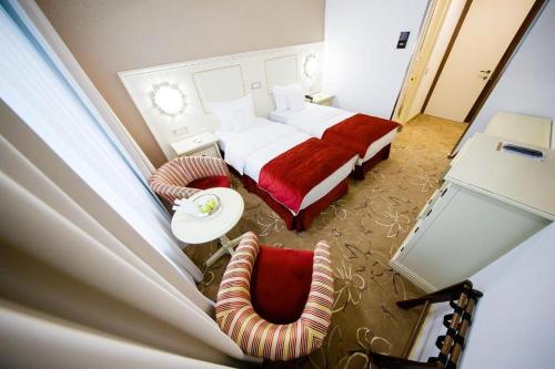 a hotel room with a bed and a chair at Pleiada Boutique Hotel & Spa in Iaşi