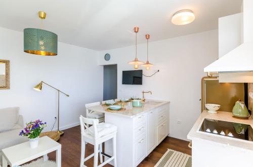 een keuken met witte kasten en een tafel in een kamer bij Apartment Rose Dubrovnik in Dubrovnik